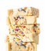 Stack of creamy Birthday Cake Fudge with colorful sprinkles on a white background